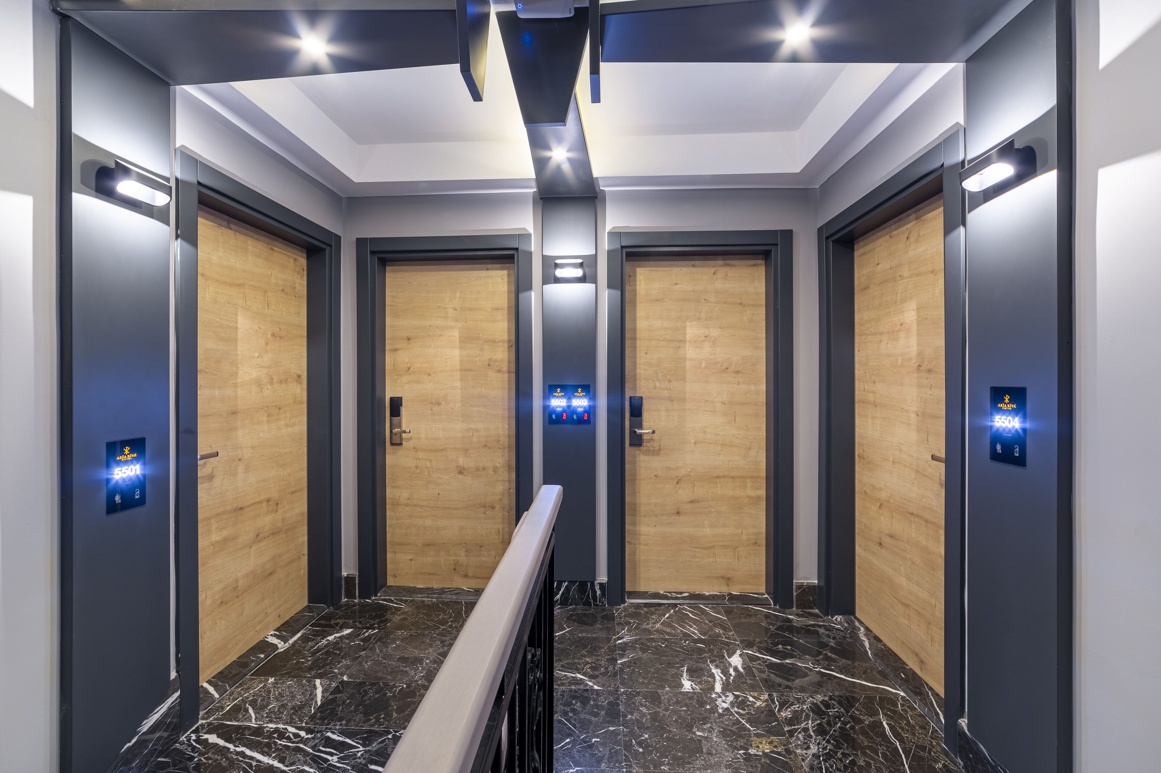 Un ascenseur au design moderne, doté d’un sol en marbre et de portes en bois.