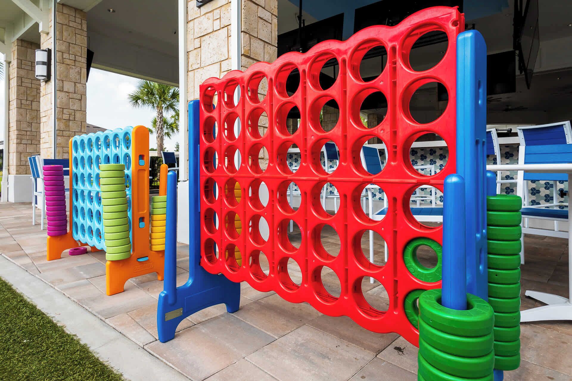 A colorful outdoor play area with various plastic structures, including a red and blue climbing frame and stacked tires.