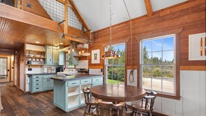 Una cocina espaciosa con una isla grande, vigas de madera y vistas al exterior.