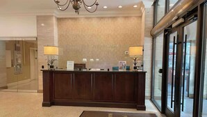 A reception desk with a marble wall and a glass door leading outside. - Come enjoy a cozy, spacious high-rise condo with breathtaking sunset views. (Atlanta)