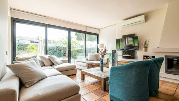 A modern living room with a sofa, a coffee table, and a TV.