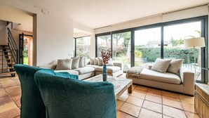 A spacious living room with a large window, a sofa set, and a coffee table.