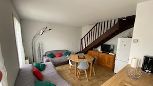 A compact living space with a sofa, dining table, and kitchen area.