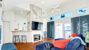 A modern living room with a blue sofa, a fireplace, and a TV.