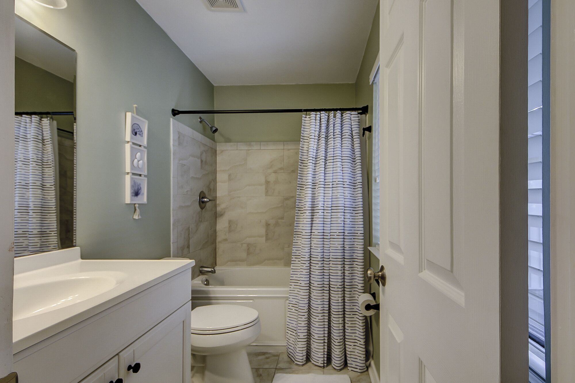 A bathroom with a shower, toilet, and sink.