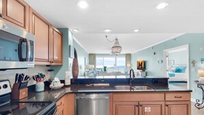 A modern kitchen with wooden cabinets, stainless steel appliances, and a central island with a sink.