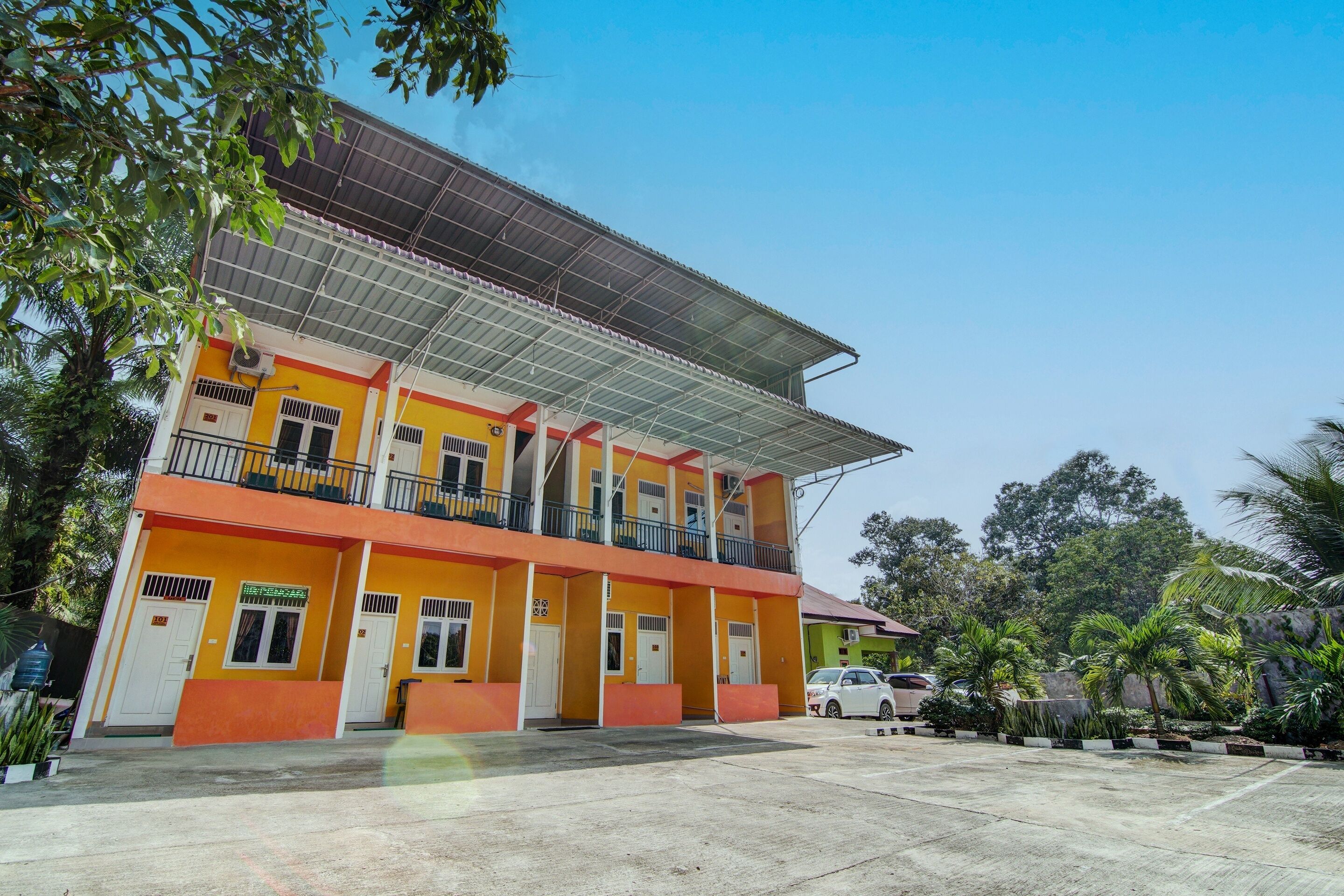 A multi-story building with a flat roof and a covered entrance.