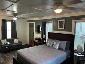 A bedroom with a bed, a desk, a chair, a ceiling fan, and a window with blinds. - Cute cottage-historic district-hot tub (Ocala)