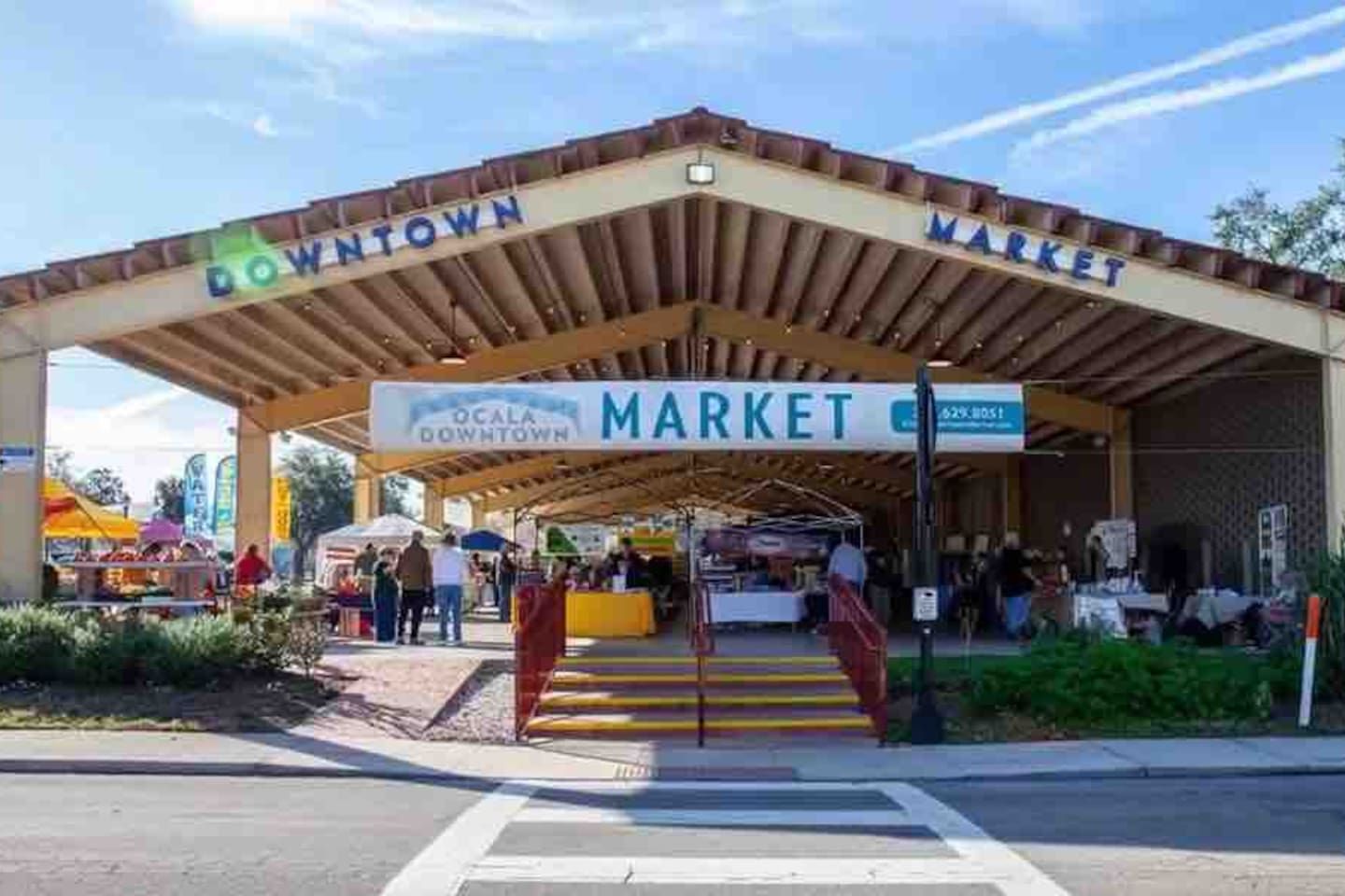 A covered market entrance with a sign for 'OCALA DOWNTOWN MARKET' and a pedestrian crossing.