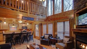 A cozy cabin interior with a dining area, kitchen, and living room.