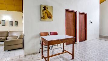 A room with a wooden table, two chairs, a sofa, and two doors.