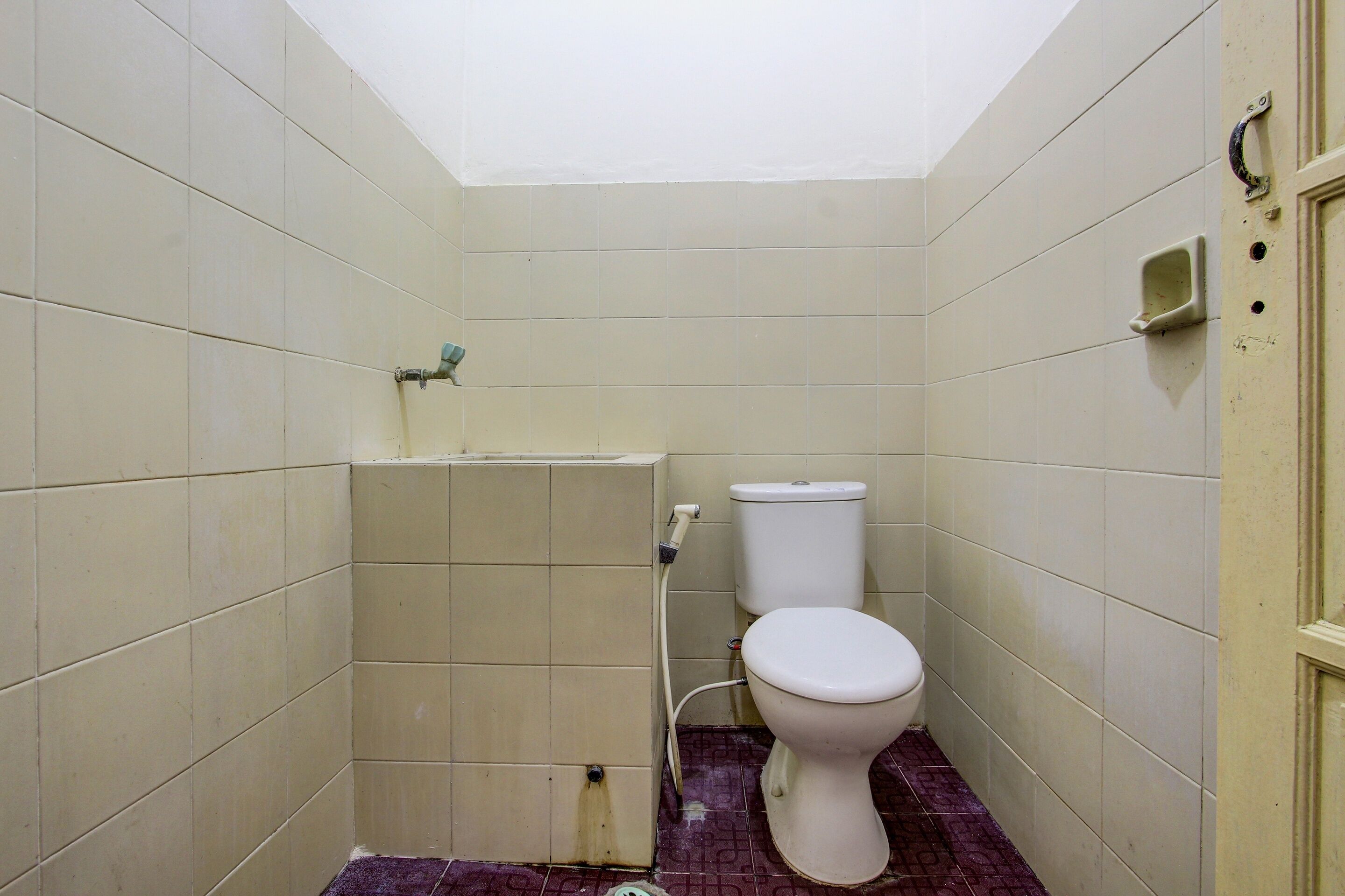A small, narrow bathroom with a toilet, a sink, and a shower.