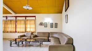 Una sala de estar con un sofá modular, una mesa de centro y una araña.