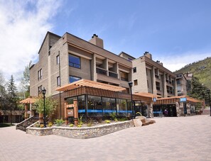 A multi-story hotel with a brick facade, large windows, and outdoor seating areas. - Vail 21 #304 1 Bedroom Condo by RedAwning (Vail)