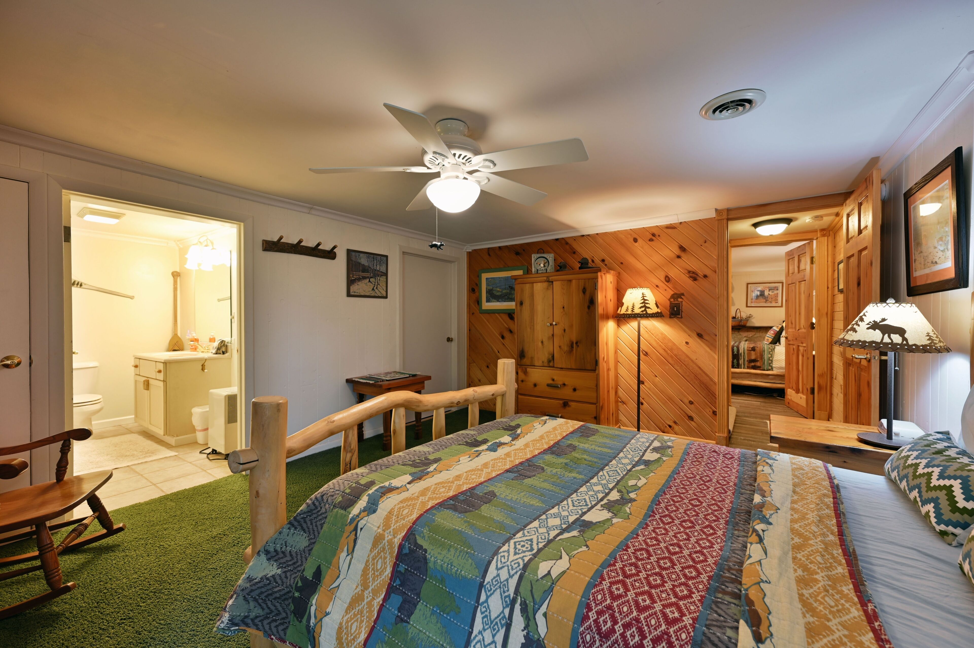 Un dormitorio con una cama grande, un armario de madera y un ventilador de techo.