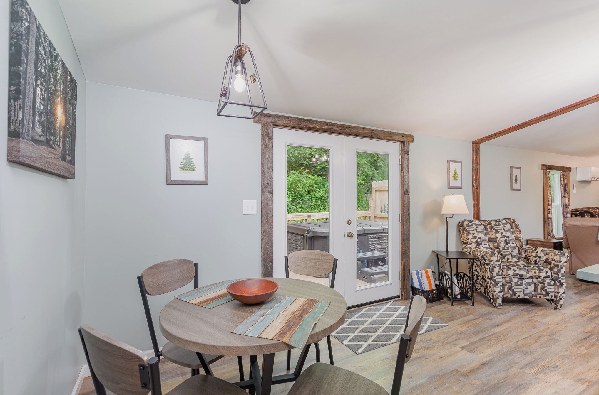 A dining area with a round table, chairs, and a bowl. There is a patterned rug on the floor.