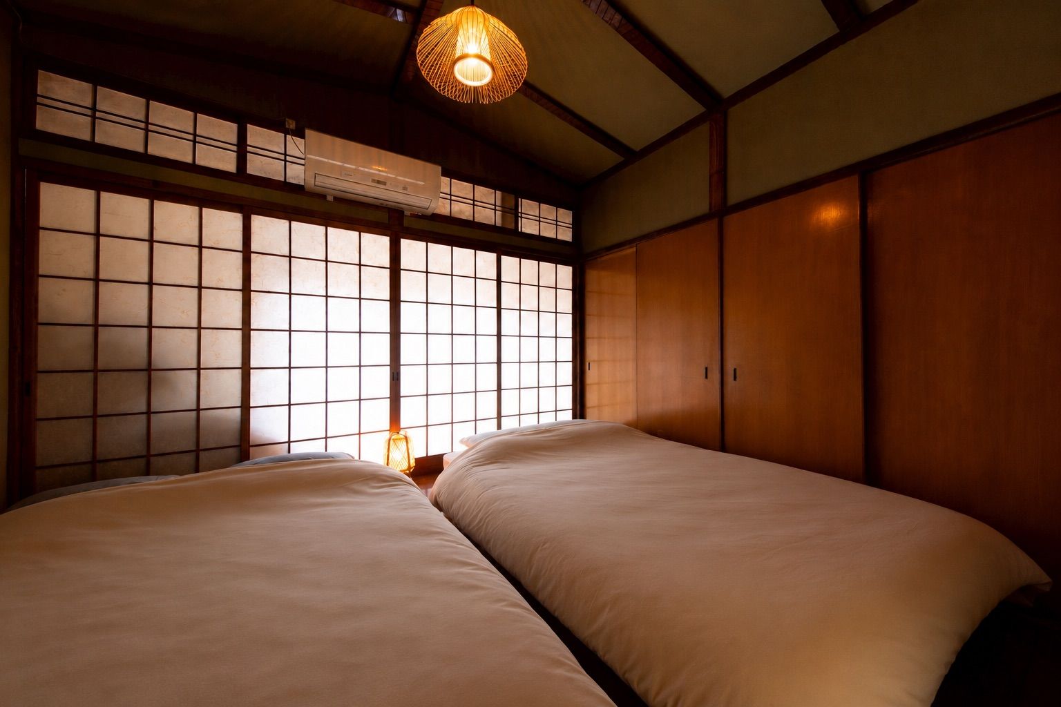 A traditional Japanese room with tatami flooring, a shoji screen, and a hanging lamp.