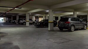 Um parque de estacionamento subterrâneo com vários andares e diversos carros estacionados.