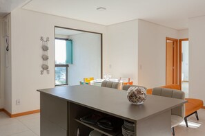 A modern dining area with a large table, chairs, and a decorative bowl. - Club Vista Mar Pertinho do Beto Carrero (Penha)