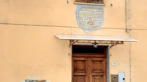 A building with a wooden double door, a small window with shutters, and a number plaque. - 2 bedroom private vacation home in Fresonara (Fresonara)