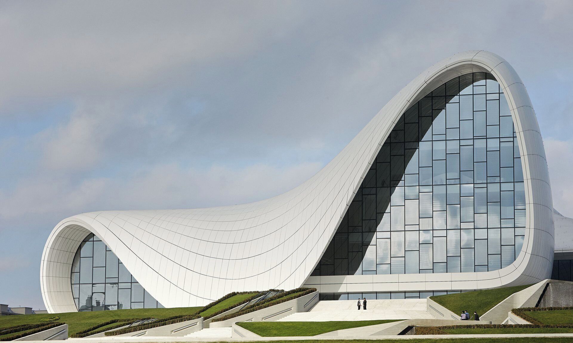 A modern architectural building with a unique curved design, large glass windows, and a spacious entrance area.