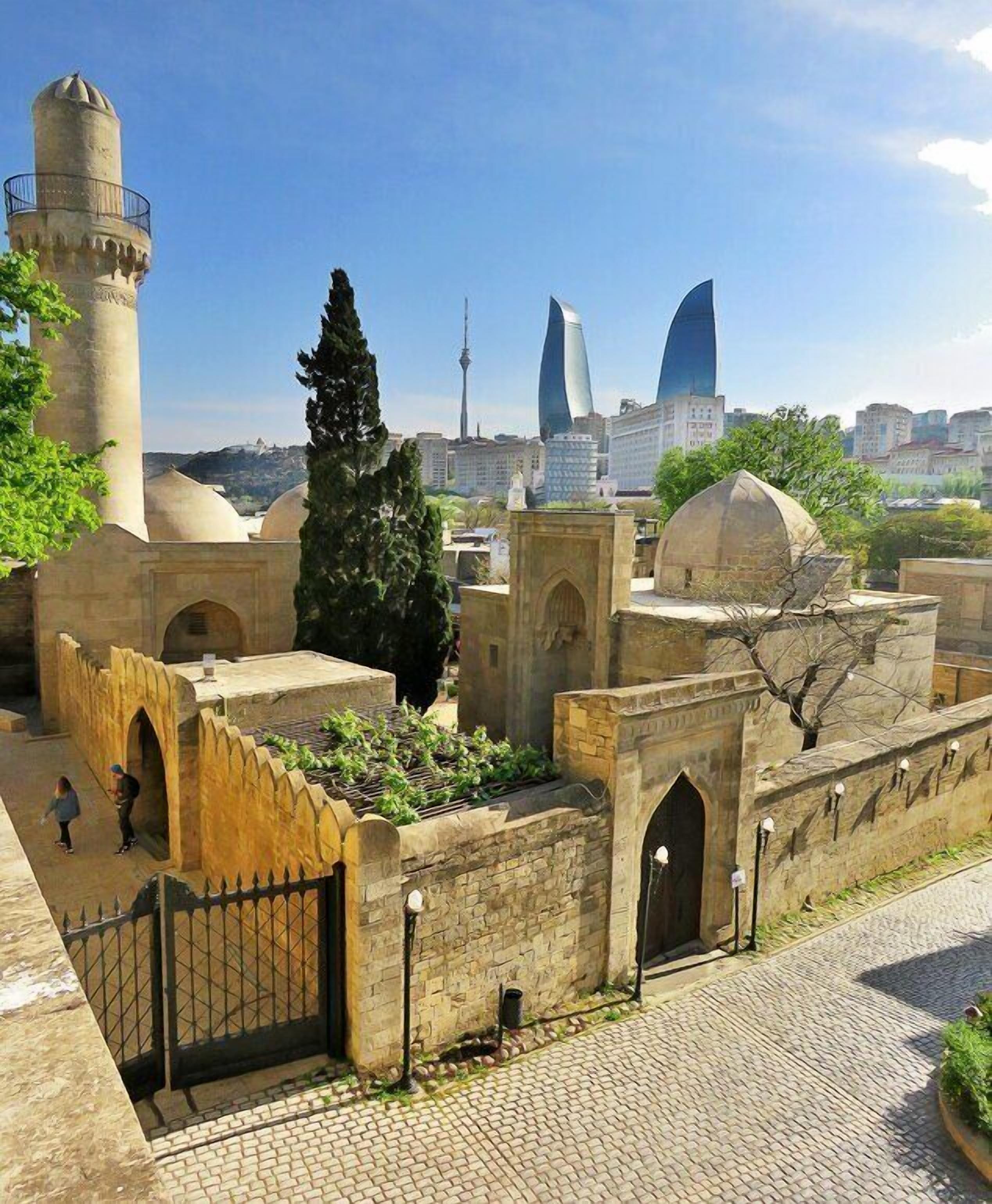 A historic fortress with stone walls, arched gateways, and a tower.