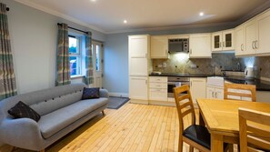 Una cocina compacta con sofá, mesa de comedor y sillas.