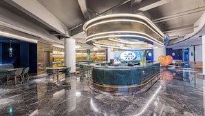 A modern lobby with a marble floor, a reception desk, and a digital screen. - Manxin Hotel Zhangjiagang Jingang Avenue Pedesrian (Suzhou)