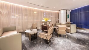 A modern lounge area with a sofa, armchairs, a coffee table, and a side table with lamps. - Manxin Hotel Zhangjiagang Jingang Avenue Pedesrian (Suzhou)