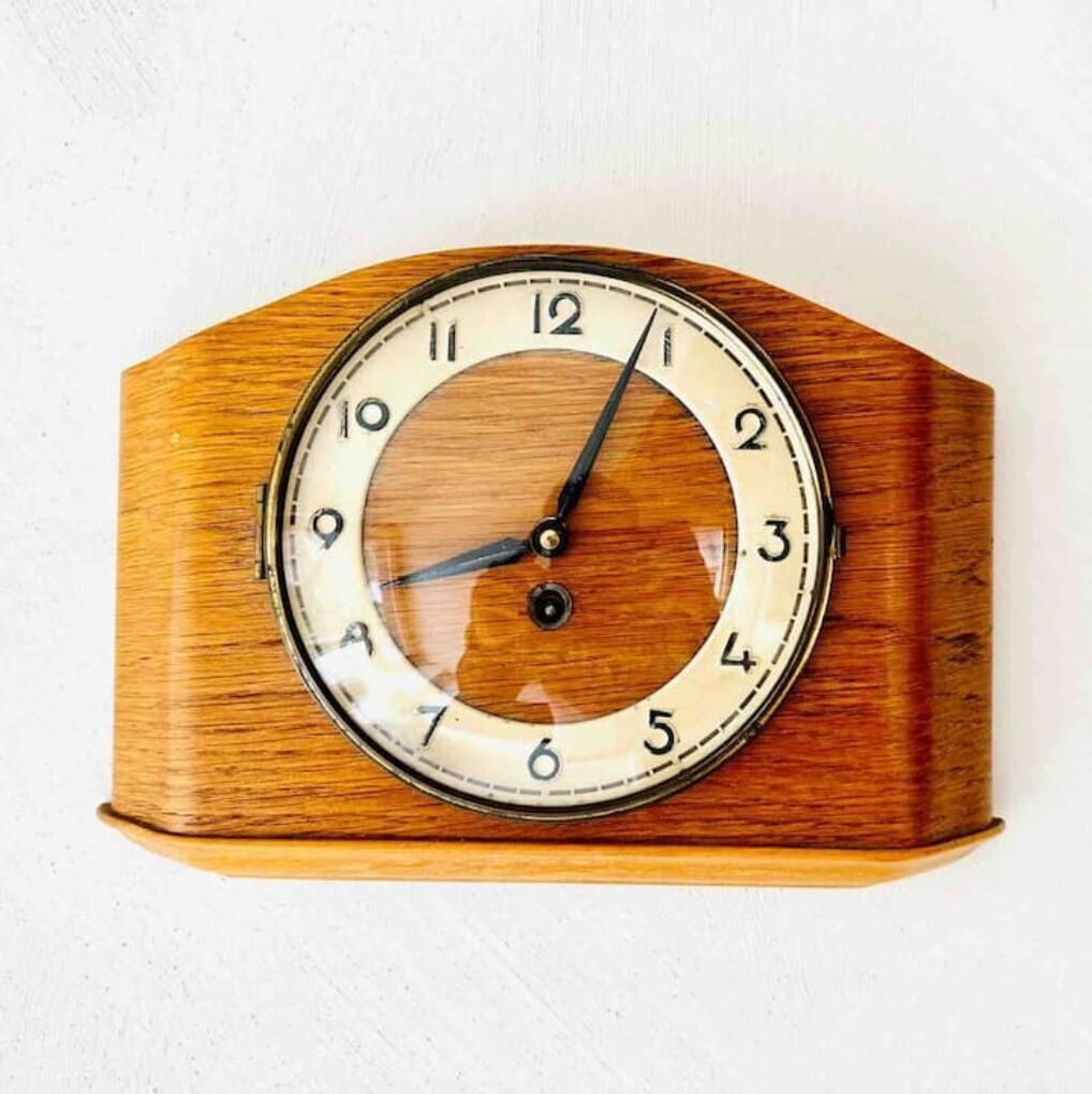 A wooden wall clock with a round face and numbers from 1 to 12.