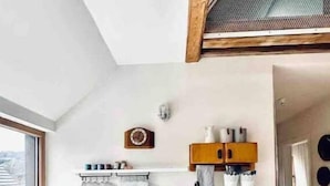 A compact kitchen with white cabinetry, a built-in oven, and a window providing natural light. - Galeriewohnung mit Ambiente (Wertheim)