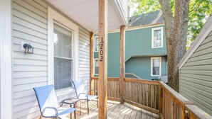 Une terrasse en bois avec deux chaises, une rambarde et le numéro de maison 3202.