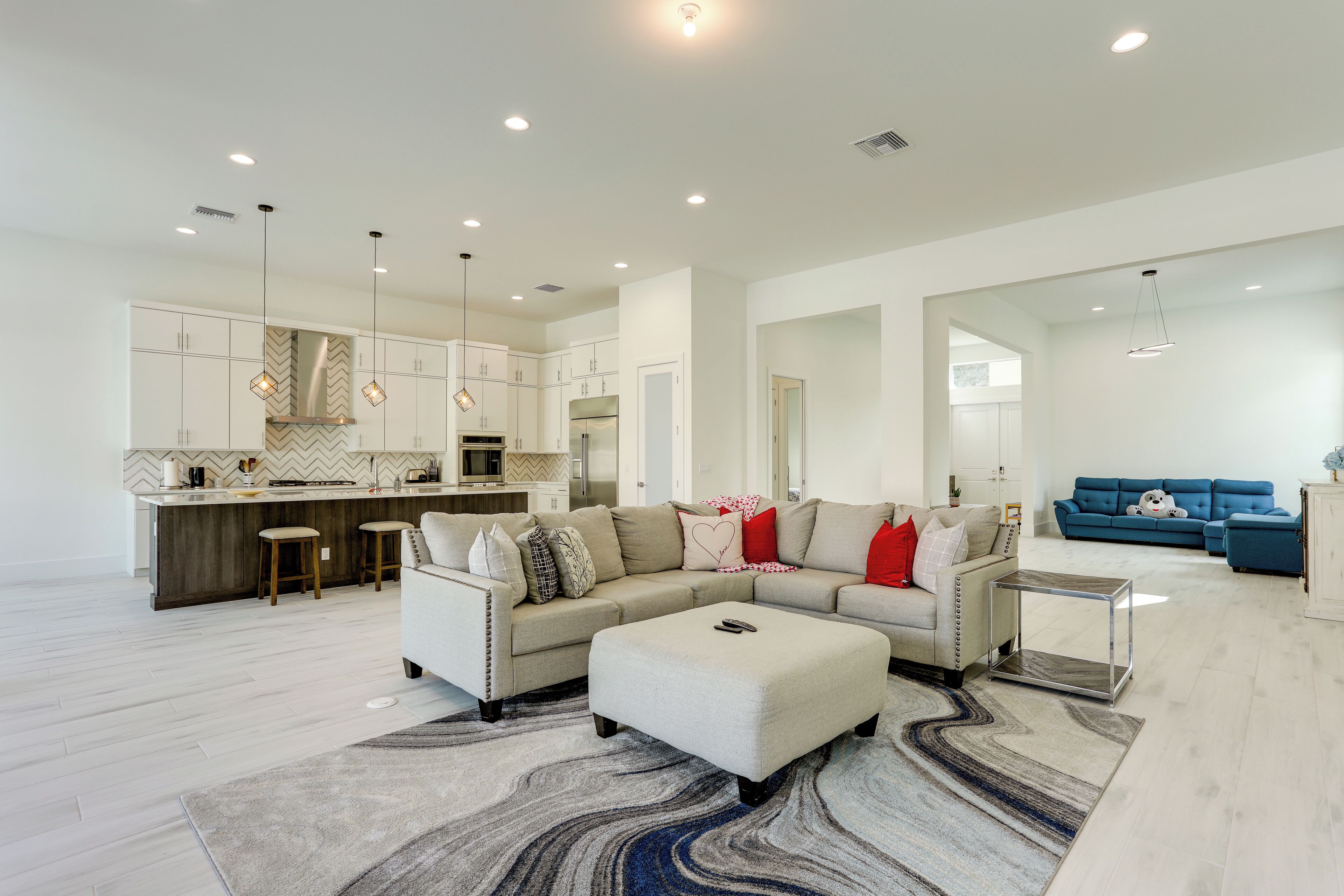 A modern living room with a sectional sofa, ottoman, and a coffee table.