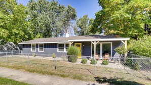 A single-story house with a porch, a fenced yard, and a small front yard. - Lovely South Bend Home ~ 3 Mi to Dtwn & Notre Dame (South Bend)