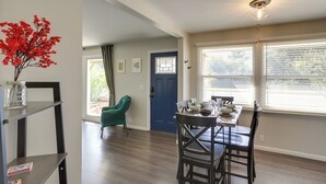 A dining area with a table set for four, a green armchair, and a blue door. - Lovely South Bend Home ~ 3 Mi to Dtwn & Notre Dame (South Bend)
