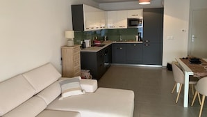 Eine moderne Wohnung mit Wohnzimmer, Küche und Essbereich.
