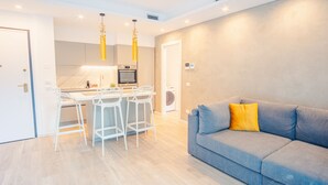 A modern apartment with a kitchen, dining area, and a living room. - Garda Luxury Suite - One Bedroom Apartment, Sleeps 2 (Padenghe sul Garda)