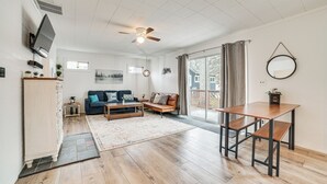 A spacious living area with a sofa, coffee table, and a dining table. - Higgins Lake Cottage w/ Private Fire Pit & Grill! (Roscommon)