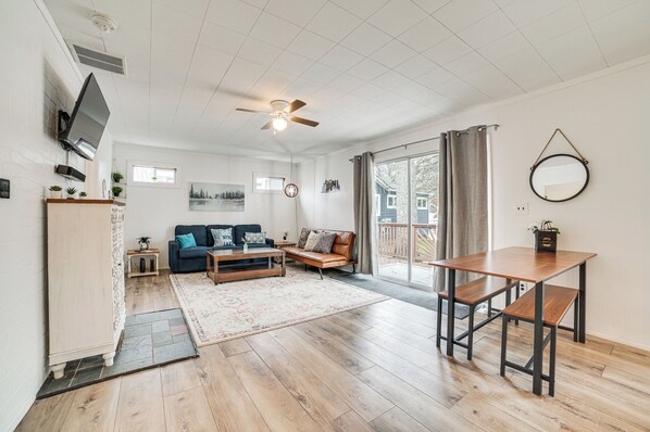A spacious living area with a sofa, coffee table, and a dining table.