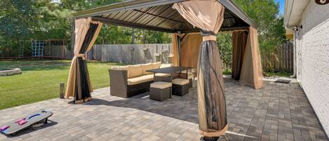A covered patio area with outdoor furniture and a skateboard.