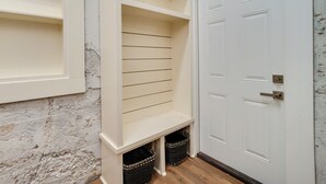 A corner of a room with a white door, a white wall, and a wooden floor.