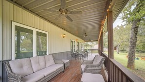 A covered porch with wicker furniture, ceiling fans, and string lights. - Cozy Checotah Retreat w/ Deck Near Eufaula Lake (Checotah)
