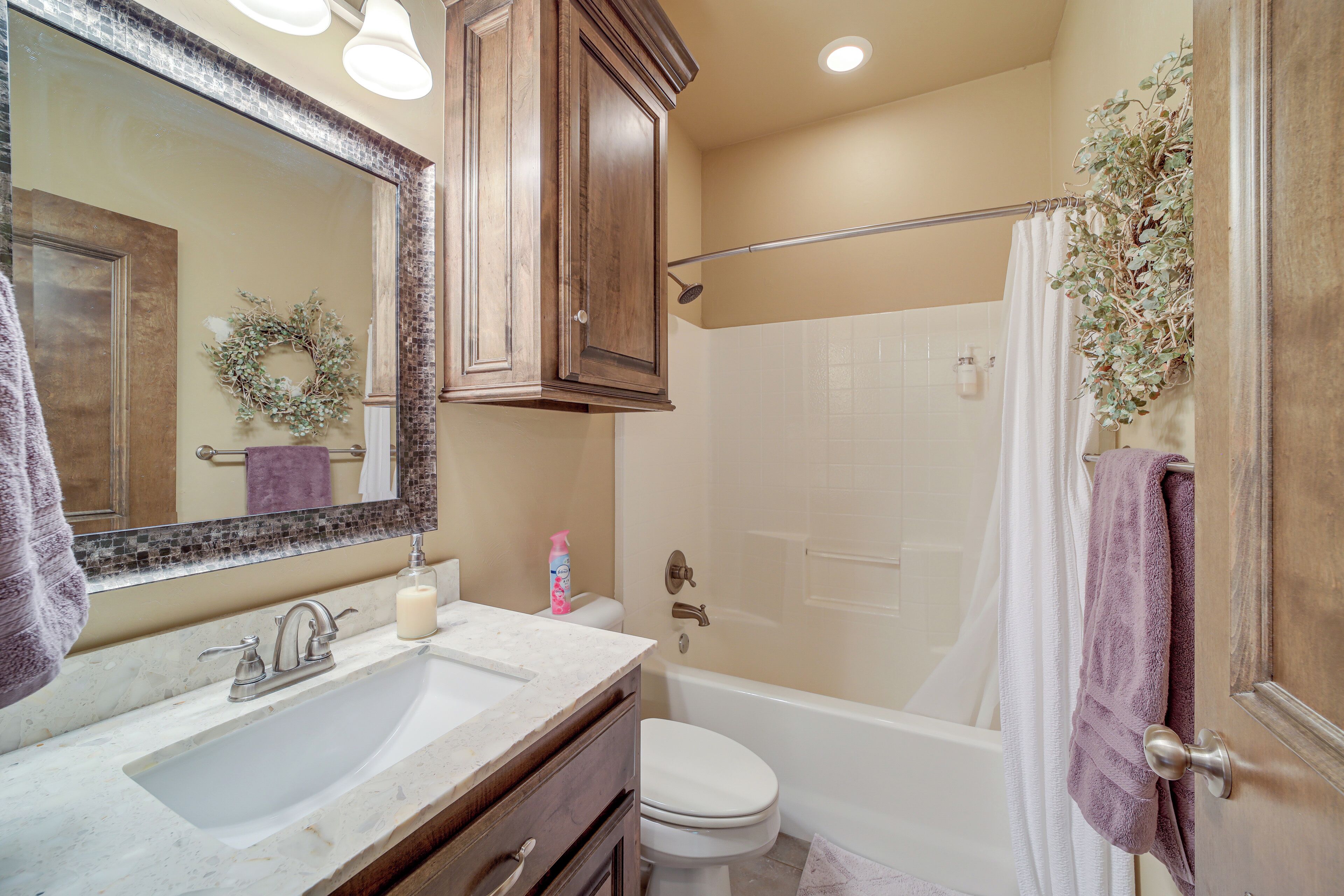 A bathroom with a sink, mirror, and shower area.
