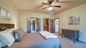 A bedroom with a large bed, a ceiling fan, a dresser, and a painting on the wall. - Cozy Checotah Retreat w/ Deck Near Eufaula Lake (Checotah)