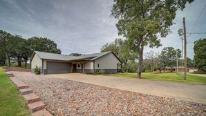 A residential house with a garage, driveway, and a gravel pathway leading to the entrance. - Cozy Checotah Retreat w/ Deck Near Eufaula Lake (Checotah)