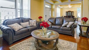 A living room with two dark brown leather sofas, a glass coffee table, and a patterned rug.