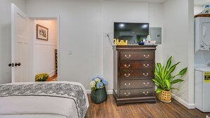 A bedroom with a bed, a dresser, a television, and a washing machine. - 5 Mi to Salem: Furnished Patio at Danvers Studio! (Danvers)