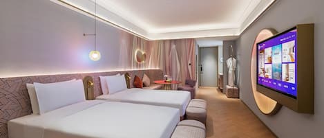 Habitación de hotel con dos camas, un televisor, una mesita y una zona de estar.