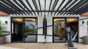 An outdoor gym area with a punching bag, exercise equipment, and potted plants. - Nun Vila Nova 2503 - Vila Nova Conceição (São Paulo)
