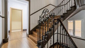 Una escalera con barandillas negras ornamentadas y peldaños de madera.